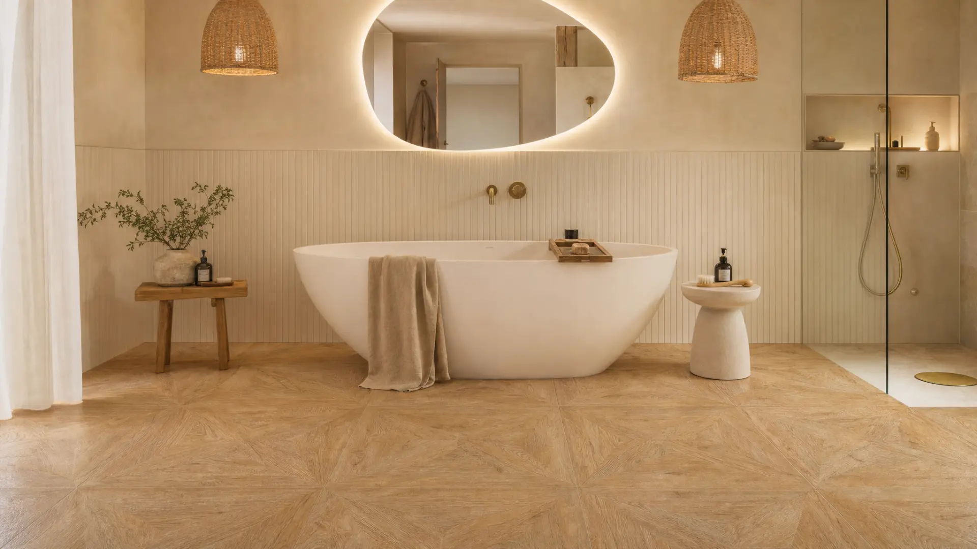 Salle de bain épurée avec baignoire îlot, sol en grands carreaux effet bois marqueté, miroir rétroéclairé et suspensions tressées